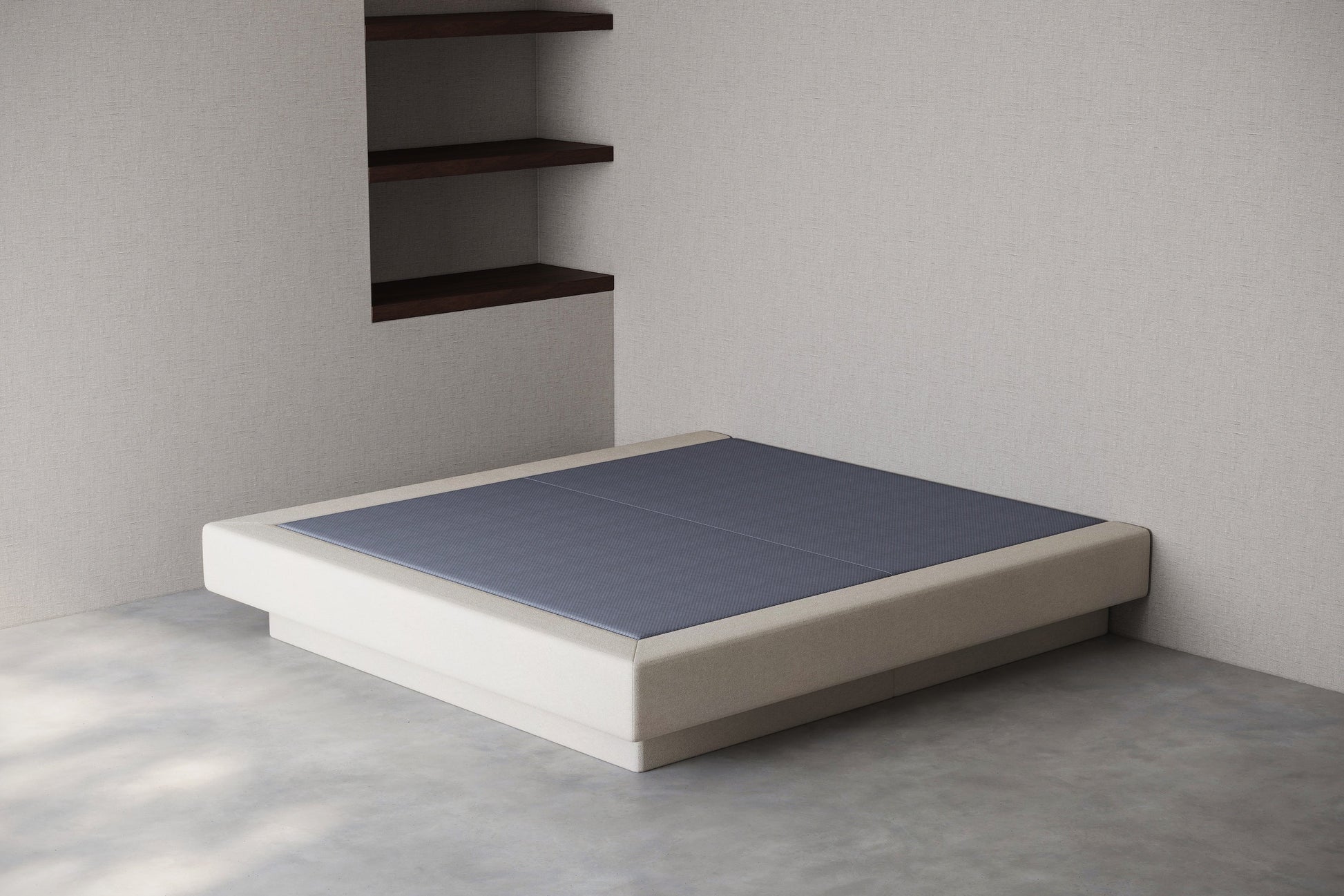 Minimalist platform bed with anti slip base against a plain wall.